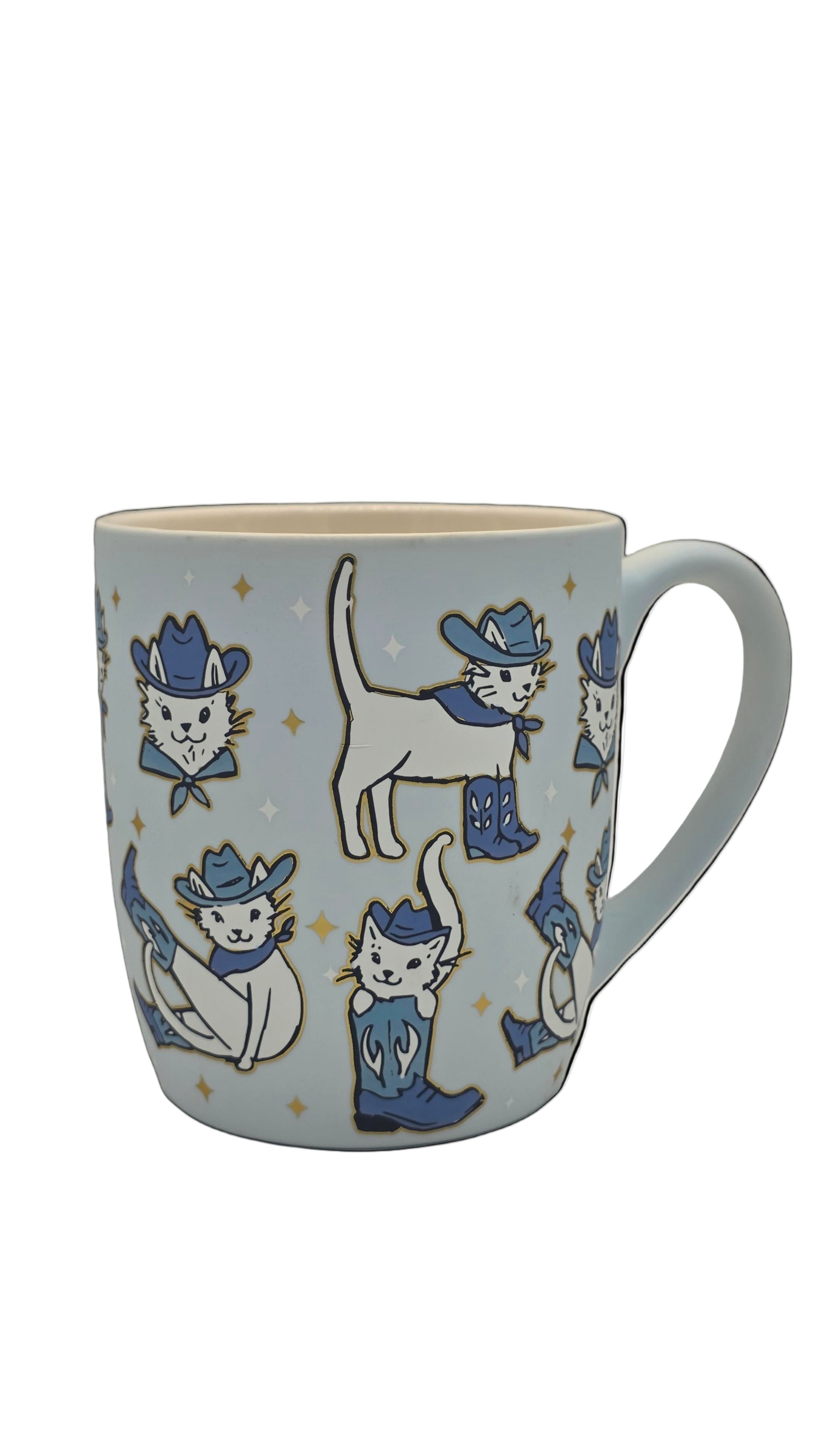 Mug with cat illustrations wearing cowboy hats and boots on a light blue background